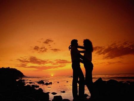 Couple amoureux au coucher du soleil en bord de mer